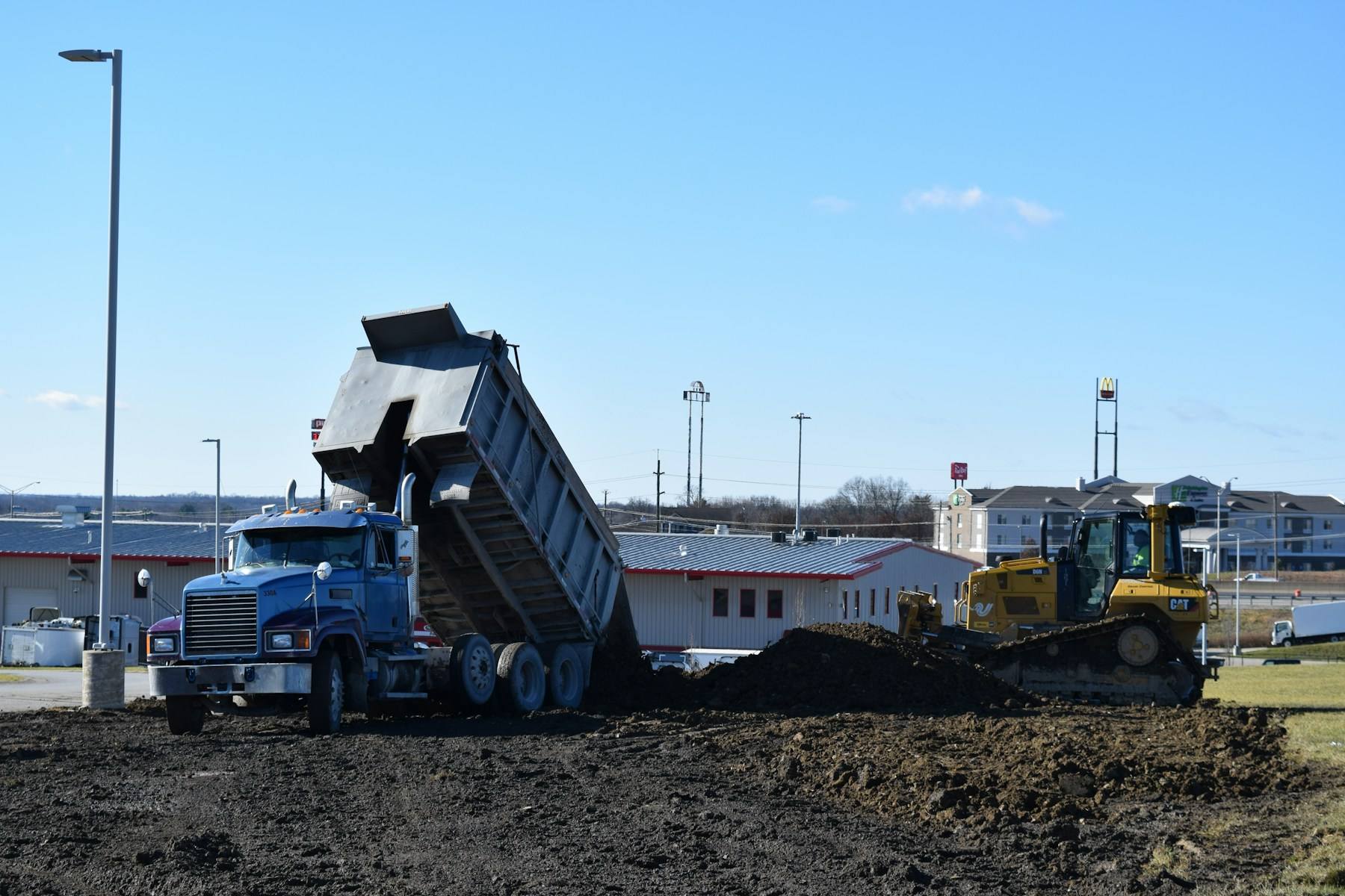 Loader and dump truck moving material on site